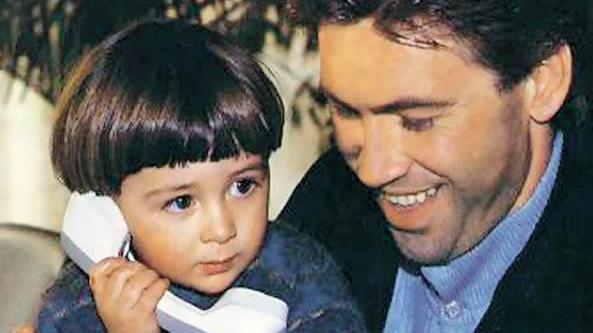 Image of Davide Ancelotti as a child, holding a telephone handset while sitting with his father, Carlo Ancelotti