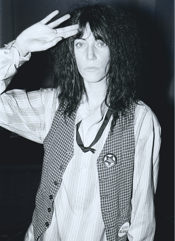 Black and white photograph of Patti Smith posing with her hand against her head.