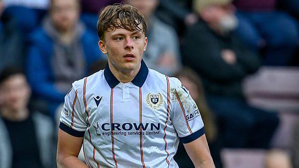 Luke Graham in action for Dundee. He is wearing a white shirt with thin orange stripes with a navy blue collar.