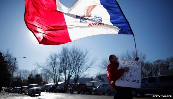 A man waves a state flag in Atlantic, Iowa, on 1 January 2012