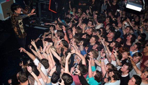 Fans take pictures on their mobiles as Bring Me The Horizon perform