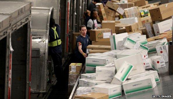 Workers with packages on an assembly line