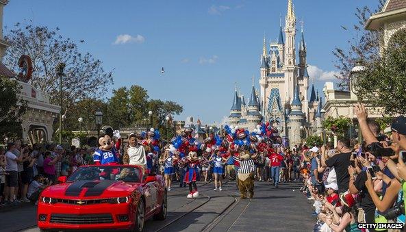 Magic Kingdom castle in background of confetti parade with Mickey Mouse