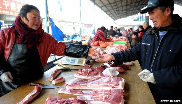 Man and woman at market in China with meat