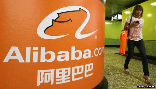 Alibaba.com ad on a board next to woman walking