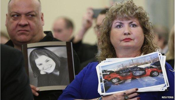 Mary Theresa Ruddy (R), whose daughter Kelly was killed in 2010 when she lost control of her 2005 Chevrolet Cobalt, holds a picture of the vehicle, while her husband Leo (L) holds a photo of their daughter