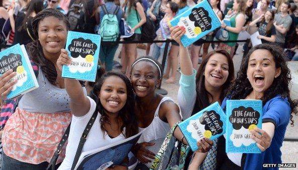 Girls holding The Fault in our stars books