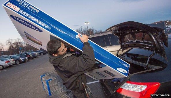 Man putting large TV into car