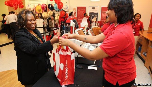 TJ Maxx associate giving shopping bag to customer