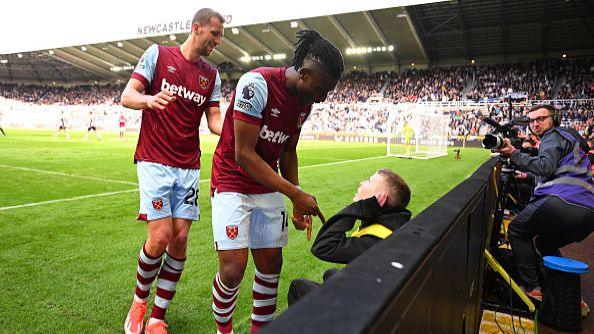 Ball boy sat on stool cups his ear at Mohammed Kudus, with Tomas Soucek behind.