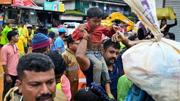 Rescue personnel escort tea plantation workers to the relief camps, after landslides in Wayanad on July 31, 2024.