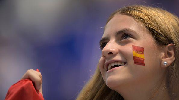 A fan of Spain looks on with facepaint on her cheek