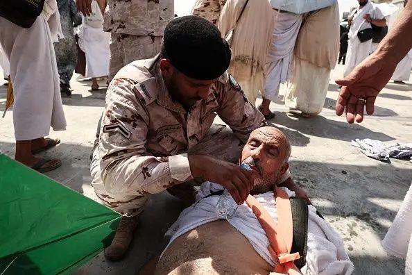 An official gives a man lying on his back water