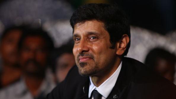 Tamil actor Vikram, wearing a black coat, white shirt and a black tie, at the audio launch of one of his films in Chennai