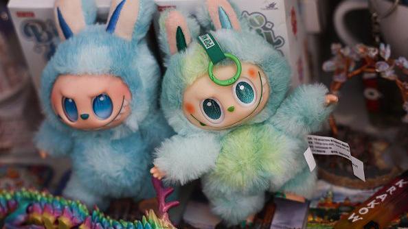 Labubu toys are seen in a shop. They have blue and green fur, large eyes and upright ears, which are part of their "monster elf" design.
