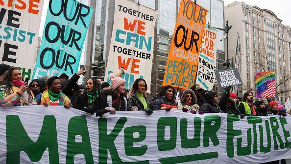 Protesters hold a banner that reads "Make our Future"