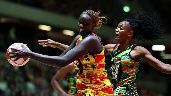  Mary Nuba Cholhok of Uganda beats Malawi's Tendai Masamba to the ball during Vitality Netball Nations Cup