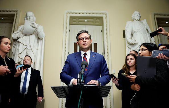 House Speaker Mike Johnson stands behind a lectern