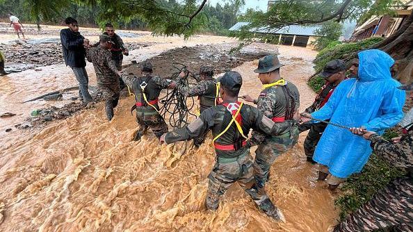 Army officials, emergency teams and civilians help rescue people at the disaster site where a landslide occured and destroyed hundreds of houses, resulting in mass fatalities in Wayanad region