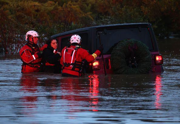 Firefighters rescue a couple after their car got stuck in floodwaters in Windsor, California