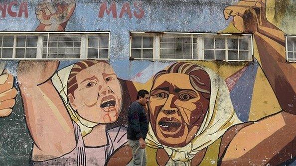 A man walks past a mural outside a public school in La Matanza, Buenos Aires province, on 9 October, 2015