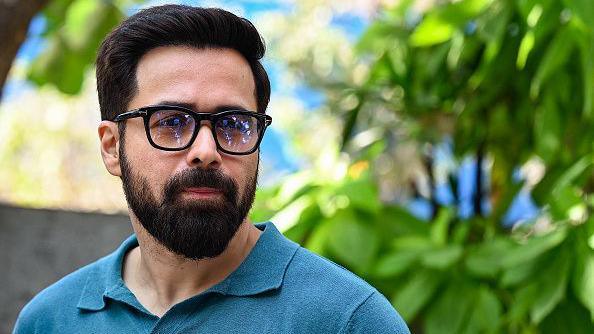 Bollywood actor Emraan Hashmi poses for pictures wearing glasses and a blue t shirt during the promotion of his web series 'Showtime' in Mumbai on February 19, 2024