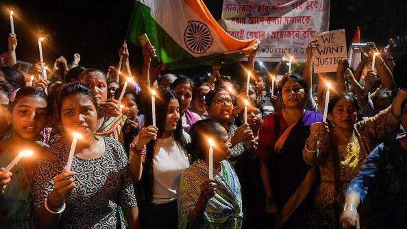 Women hold lit candles as they take part in a vigil named 'Reclaim the Night' on 15 August in Kolkata