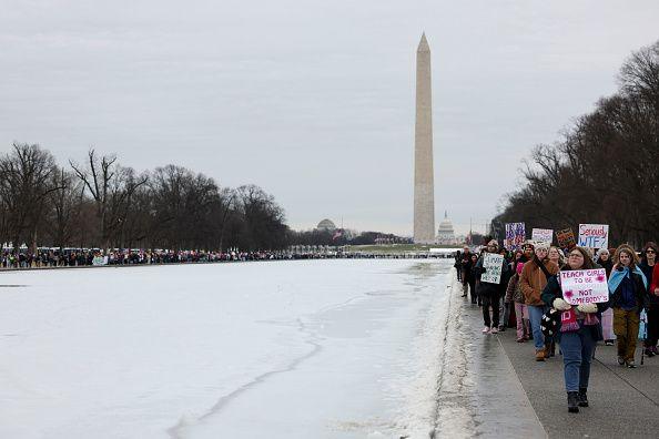 Protesters walk along the National Mall near the Washington Monument