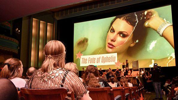 Taylor Swift fans listen to a song during a listening event for Swift's new album 'The Life of a Showgirl' at the Astor Theatre in Melbourne on October 3, 2025. They are seated in a cinema space and some are dressed up in 1920s clothes.