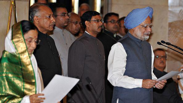 Indian Prime Minister Manmohan Singh (R) wearing a white shirt with a navy blue jacket and a blue turban takes an oath of office at a swearing in ceremony in front of Indian President Pratibha Patil (L) who is wearing a green and white saree with gold embellishments at the Presidential Palace in New Delhi on May 22, 2009.