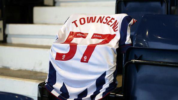 A lone West Bromwich Albion shirt is draped over the seat of West Bromwich Albion fan Mark Townsend, with his name and age on the back, 