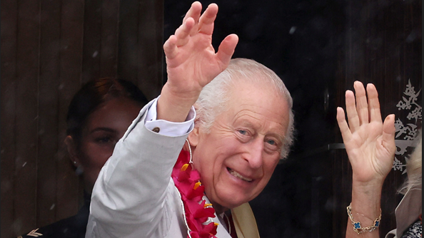 King Charles waves while boarding a plane