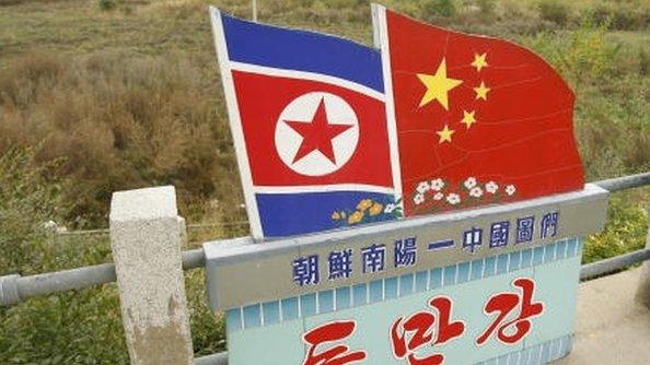 Chinese and North Korean National flags on the Chinese/North Korean border in the town of Tu Men in China's northeast Jilin province 12 October 2006