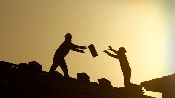 Construction workers pass bricks to each other in Phoenix, Arizona