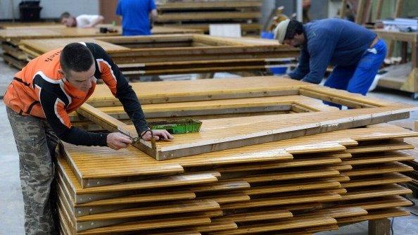 2 men working on wooden window panes