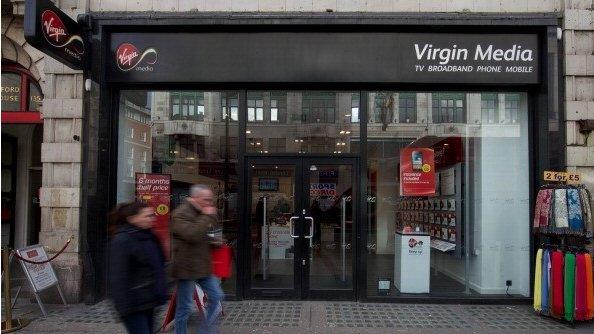 People walking past a Virgin Media shop