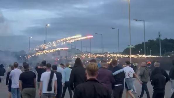 A crowd of people with fireworks exploding over them.