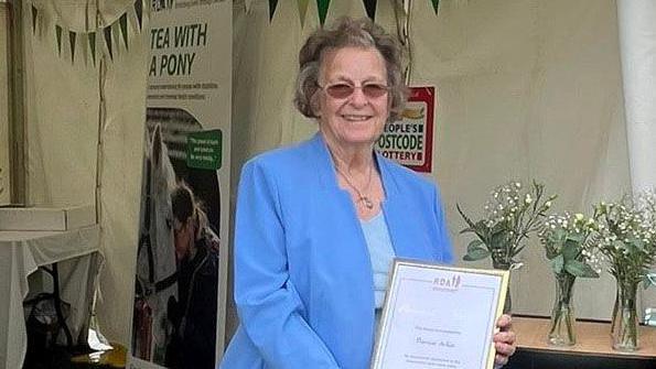 Pat Atkin holding a certificate