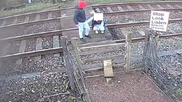 CCTV shows a child squatting down on the railway track