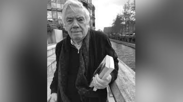 A back and white picture of Prof Gary Browning, holding two books. He is outside, by a river.