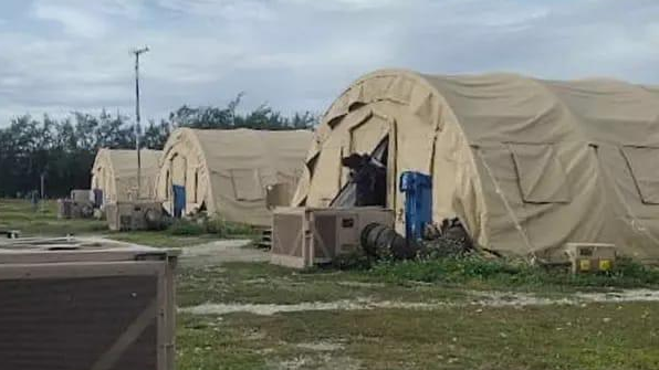 Three large tents stand in a row on grassland on Diego Garcia