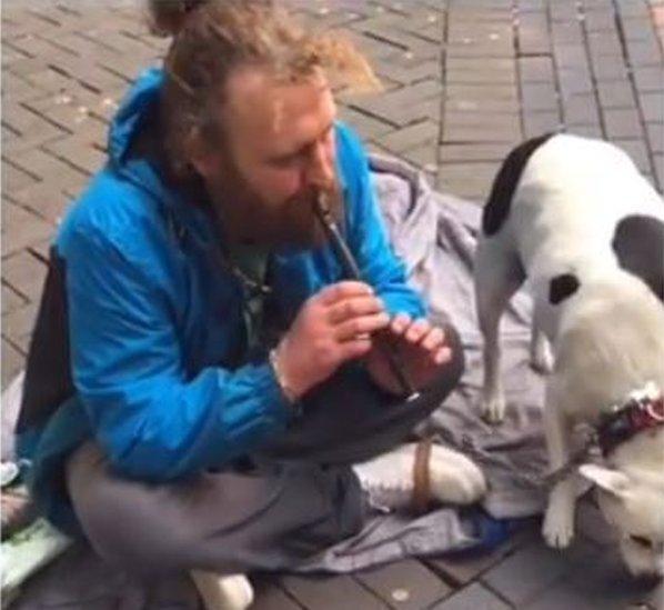 Nathan playing the flute next to his dog