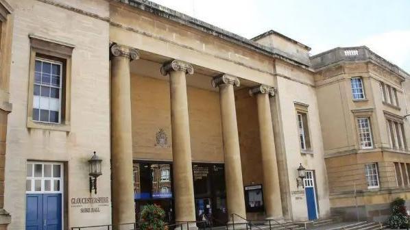 Shire Hall entrance, with pillars running down the front of the sand-coloured building.