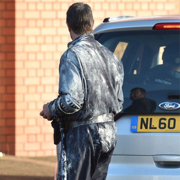 A member of a Tornado team leaves HMP Birmingham covered in paint