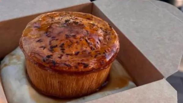 A pie in a brown cardboard box