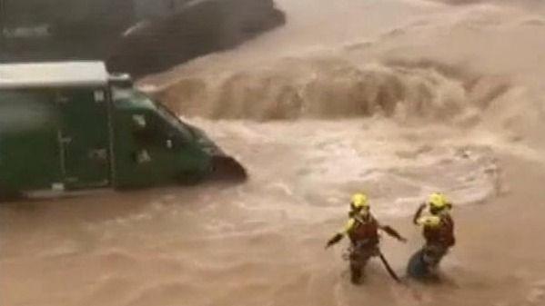 Firefighters wade to stranded vehicle in Alzira, Valencia, in Spain