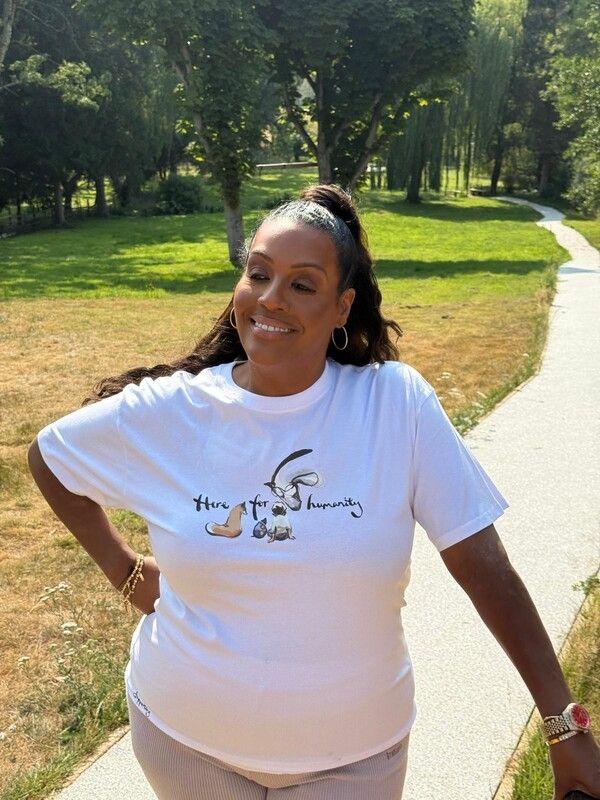Alison Hammond stands outside wearing the white "Here for Humanity" t-shirt.