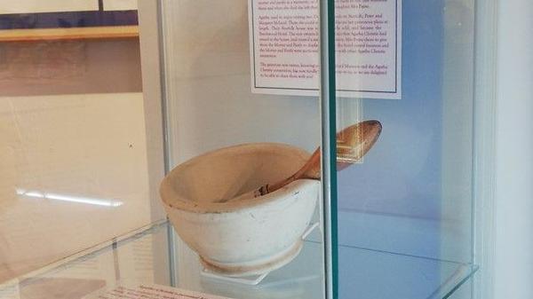 Mortar and pestle exhibited behind a glass cabinet.