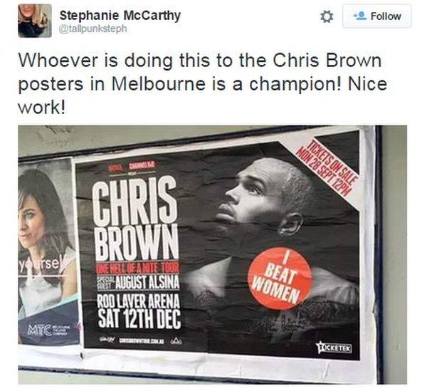 An "I Beat Women" sticker is placed on one of Chris Brown's promotional posters