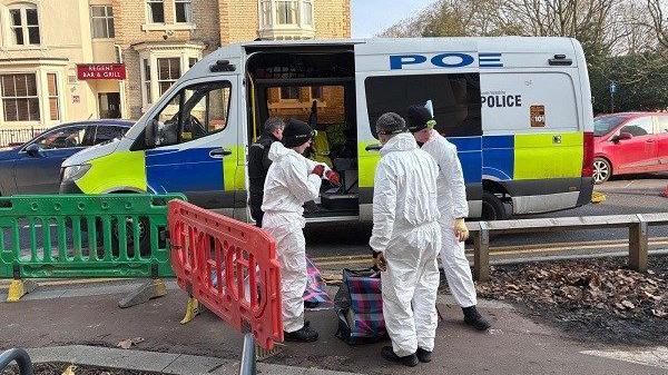 Police in forensic suits next to a police van on a Doncaster street 